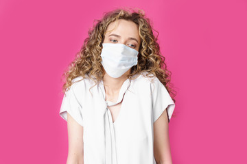 Young woman with a medical mask on her face shrugs.