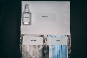 a small bottle of sanitizer with packed mask and gloves 