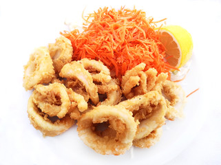 Fried squid rings with lemon and carrot salad on white