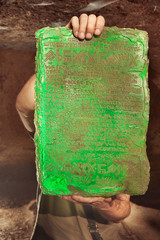 Detail of mysterious artifact emerald tablet found by adventurer in cave