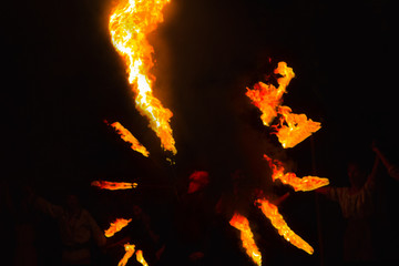 Fire show at an event in the dark. Fire show. The fakir waves fire against the explosion of firecrackers. Nightly entertainment performance great show. Fire show, dancing with flame