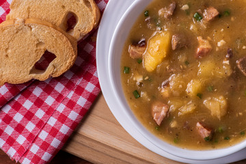 .Cassava broth. Creamy broth made with cassava, sausage, bacon and meat. .Accompanied by toast Top view Top view