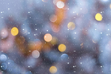 Obraz na płótnie Canvas Winter abstract background with flying snow and colorful bokeh