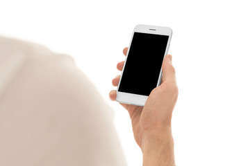 Fototapeta na wymiar Man holding a smartphone with empty black screen. Mobile phone in a vertical position in hands and isolated on white background. Studio shot. Third person view. Camera shot from over shoulder.