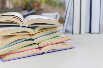 Close up, Desk with stack of open study books. Textbooks for the student, university. Study from home. Distance education concept.