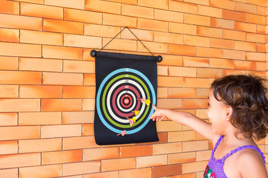 Crian&ccedil;a brincando de jogar dardo 