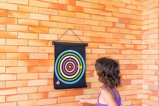 Crian&ccedil;a brincando de jogar dardo 