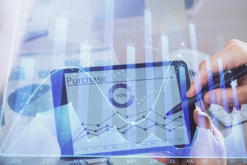 Double exposure of man's hands holding and using a phone and financial chart drawing. Market analysis concept.