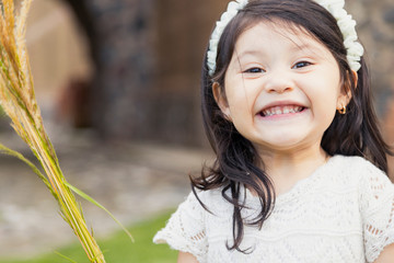 Portrait of Hispanic girl dressed in white smiling at camera - Happy girl showing teeth while...