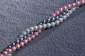 Three strands of pearls in grey, white and pink