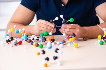 Young male scientist sitting in the classroom