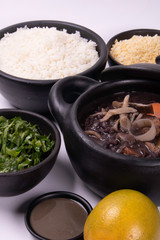 vegan feijoada with side dishes: rice, farofa, kale and orange