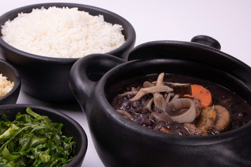 vegan feijoada with side dishes: rice, farofa, kale and orange