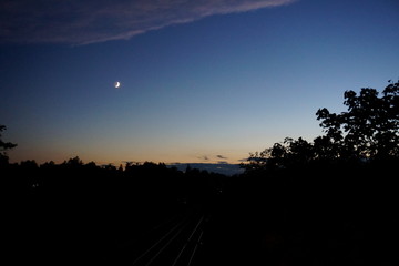 Sunset mood in the city with moon at the sky