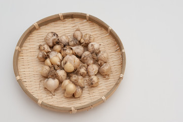 Organic garlic (Allium sativum) in woven bamboo basket. Isolated on white background. Copy space.