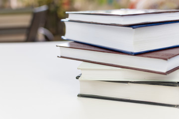 Desk with stack of study books. Textbooks for the student, university. Study from home. Distance education concept.