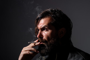 Handsome man smoke the cigarette. Hipster with cigarette. Cigarette smoke. Sensual man smoking outside. Tobacco. Smoking hipster. Sensual bearded man with cigarette.