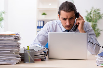 Young male businessman employee unhappy with excessive work
