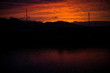 Obraz premium 夕焼け空 遠景 山並み 水面