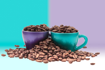 Cups of coffee filled with grain in a heap of beans in pastel colors background