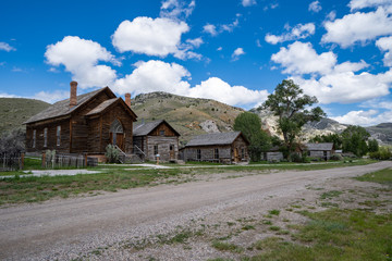 Fototapeta na wymiar Dirt road filled with abandoned homes and buildings in Bannack Ghost Town in Montana