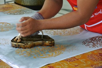 KUALA LUMPUR, MALAYSIA -JUNE 25, 2016: Handmade stamping batik. An artist press get batik pattern using the mold or pattern block of batik tekap or stamp batik.   - obrazy, fototapety, plakaty