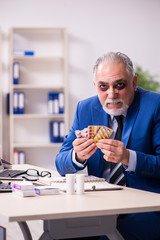 Old face injured employee sitting in the office