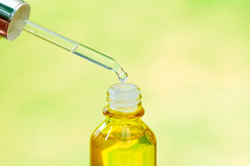 hands of a beautiful woman Dropping serum collagen moisturizer of face into hand soft light background. Protector skin Treatment facial essence oil, Vitamin C. Beauty and spa concept