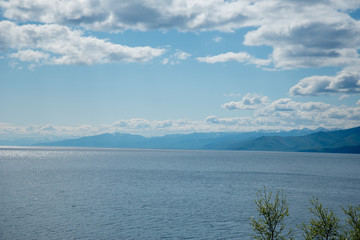 The coast of Lake Baikal on the Circum-Baikal Railway. Circum-Baikal railway tour in Siberia with trees, cliffs and mountains at coast. 
Baikal.
