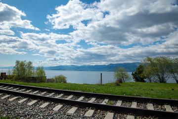 Fototapeta premium The coast of Lake Baikal on the Circum-Baikal Railway. Circum-Baikal railway tour in Siberia with trees, cliffs and mountains at coast. Baikal. 