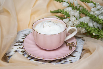 Morning coffee. Cup of coffee, latte with flowers on light background. Coffee concept