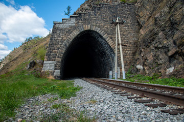 Fototapeta na wymiar Old tunnel on Circum-Baikal Railway, lake Baikal. Baikal. View from one tunnel to other tunnel. Circum-Baikal Railway. Irkutsk region.