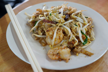 Wok-fried flat rice noodles with shrimps, egg, bean sprouts, chives, soy sauce and chili paste. Famous Penang street food - Char Koay Teow