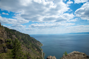 The coast of Lake Baikal on the Circum-Baikal Railway. Circum-Baikal railway tour in Siberia with trees, cliffs and mountains at coast. 
Baikal.
