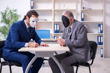 Two businessmen wearing masks during negotiations