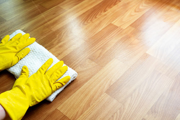 Close-up of a girl's hands washing the floor in a bright room in yellow household gloves. Clean and fresh.