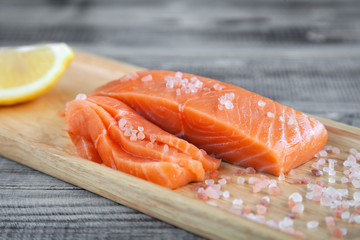 Salmon fresh raw fish fillet on wooden cutting board