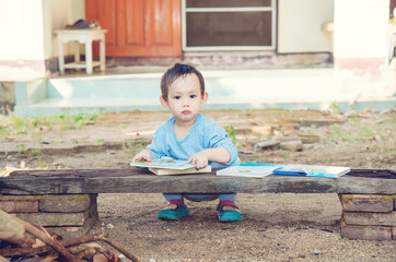 Asian baby boy reading tale book alone