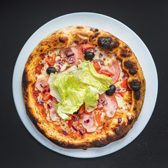 pizza on the black background, top view