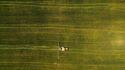 Minimalistic overhead shot of a combine mowing a grass field