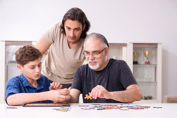 Three generations of family playing jigsaw puzzle game