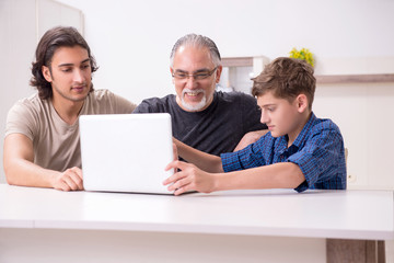 Grandfather learning new technology from son and grandson