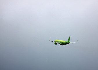 Passenger plane flying in dull sky. Side-view of aircraft. Image contains copy space