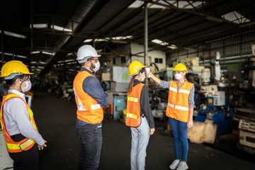 Factory in new normal. Worker uses infrared thermometer measuring temperature with  staff scanning for Coronavirus or Covid-19 symptom at factory entrance. International medical healthcare system