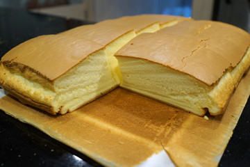 Freshly Baked Taiwanese Fluffy Egg Sponge Cake on wooden cutting board.
