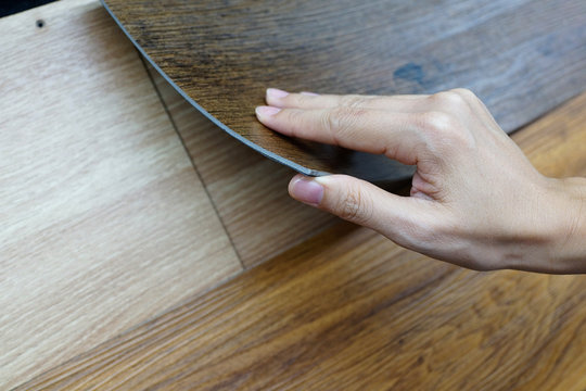 Cropped hand holding a sample vinyl flooring