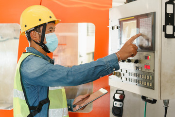 Asian man engineer  working on machine control panel display on tablet digital 