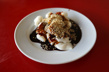 A plate of rice noodle roll with sweet sauce and chili paste also known as Chee Cheong Fun, Cantonese dish, Dim Sum meal.