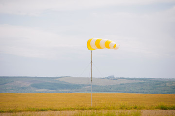 Photo of windsock indicator of wind on runway airport.