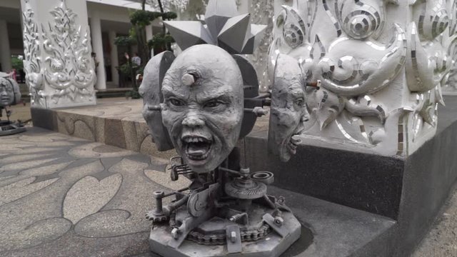 Chiang Rai, Thailand - Wat Rong Khun The White Buddhist Temple Beautiful bizarre Southeast Asian Architecture - Ubosot The principal building - Scary Head Statue